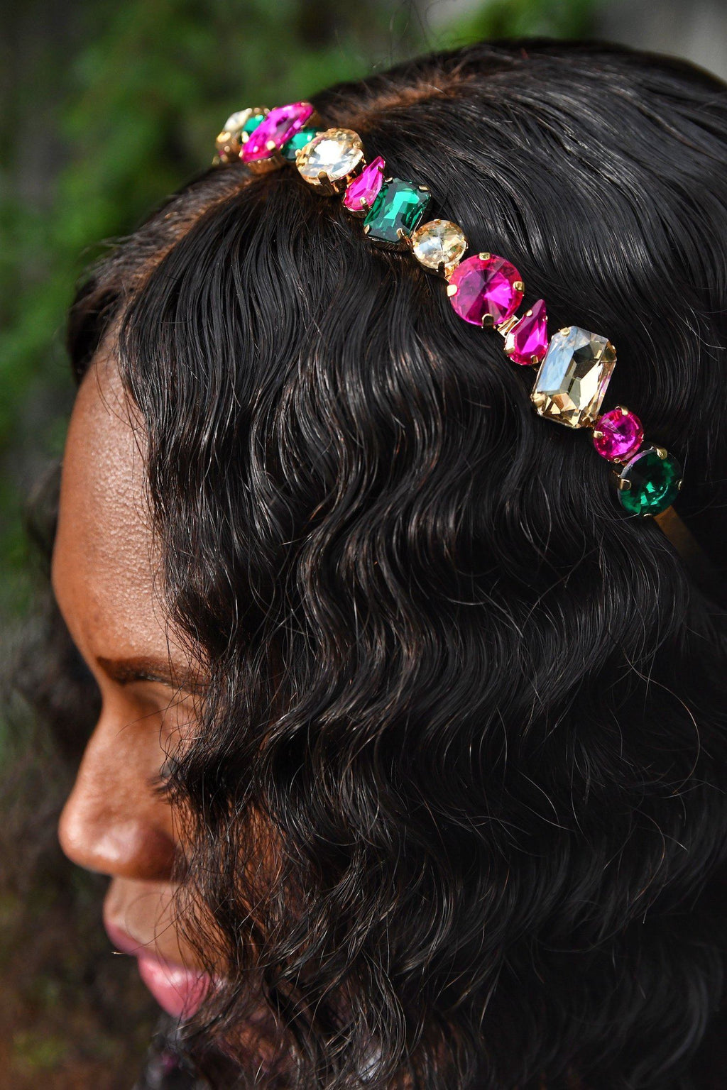 black girl with wavy hair wearing pink and green gemstone jewel headband